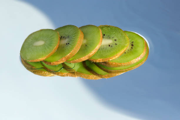 Sliced ​​ripe kiwi slices close-up. Tropical fruit on a blurred blue background .space for text