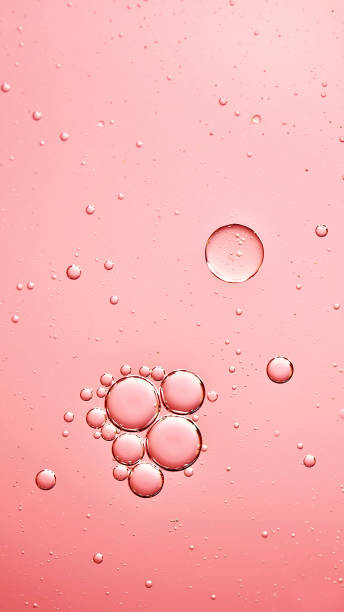 istock oil with bubbles on on coral pink background. Abstract background. 1312518192