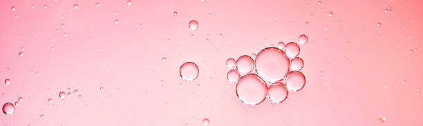 oil with bubbles on coral background. Abstract background.