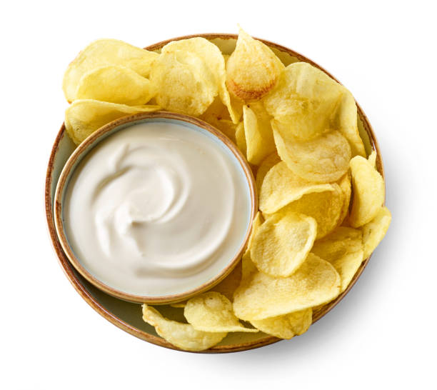 bowl of potato chips and sour cream souce bowl of potato chips and sour cream souce isolated on white background, top view dipping sauce stock pictures, royalty-free photos & images