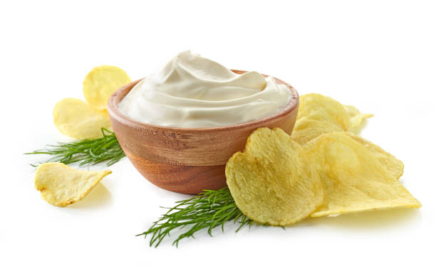 potato chips and bowl of sour cream potato chips and bowl of sour cream dip isolated on white background dipping sauce stock pictures, royalty-free photos & images