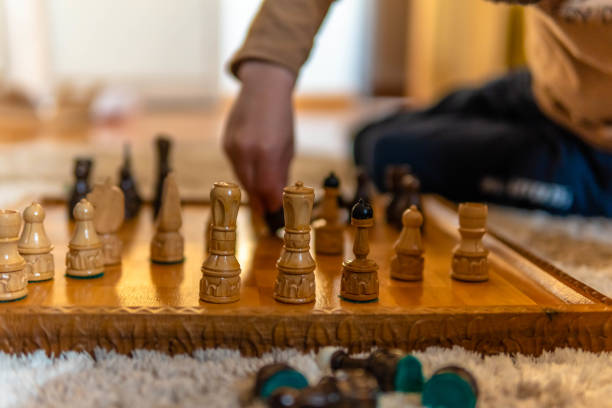 istock A young boy playing chess. He is sitting on the floor playing chess 1312528155