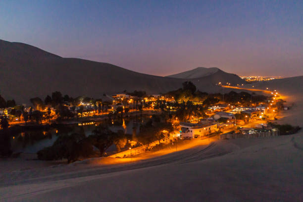 wieczorny widok oświetlonej pustynnej oazy huacachina w pobliżu ica, peru - ice zdjęcia i obrazy z banku zdjęć