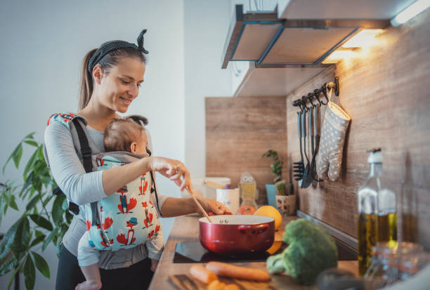 istock Woman with baby cooking in her kitchen. 1312528312