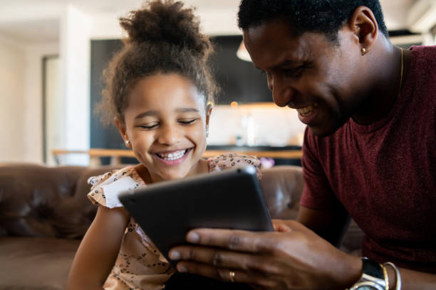 istock Father and daughter using digital tablet at home. 1312532083
