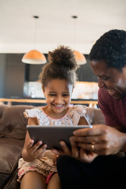 istock Father and daughter using digital tablet at home. 1312532086