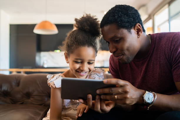 istock Father and daughter using digital tablet at home. 1312532097