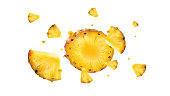 Slices of pineapple with droplets of juice in flight.