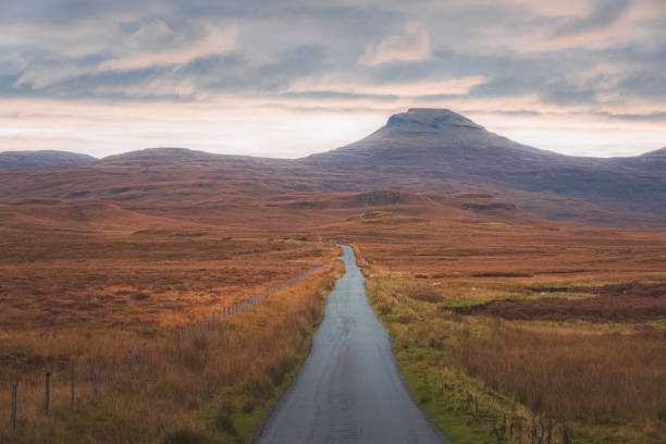 Straight ahead view of empty country road in rural countryside landscape of the Scottish Highlands at Lonmore on the Isle of Skye, Scotland.
