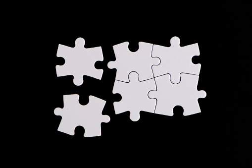 Jigsaw puzzle pieces on black background. Four Puzzle Pieces Connected, copy space for your text.