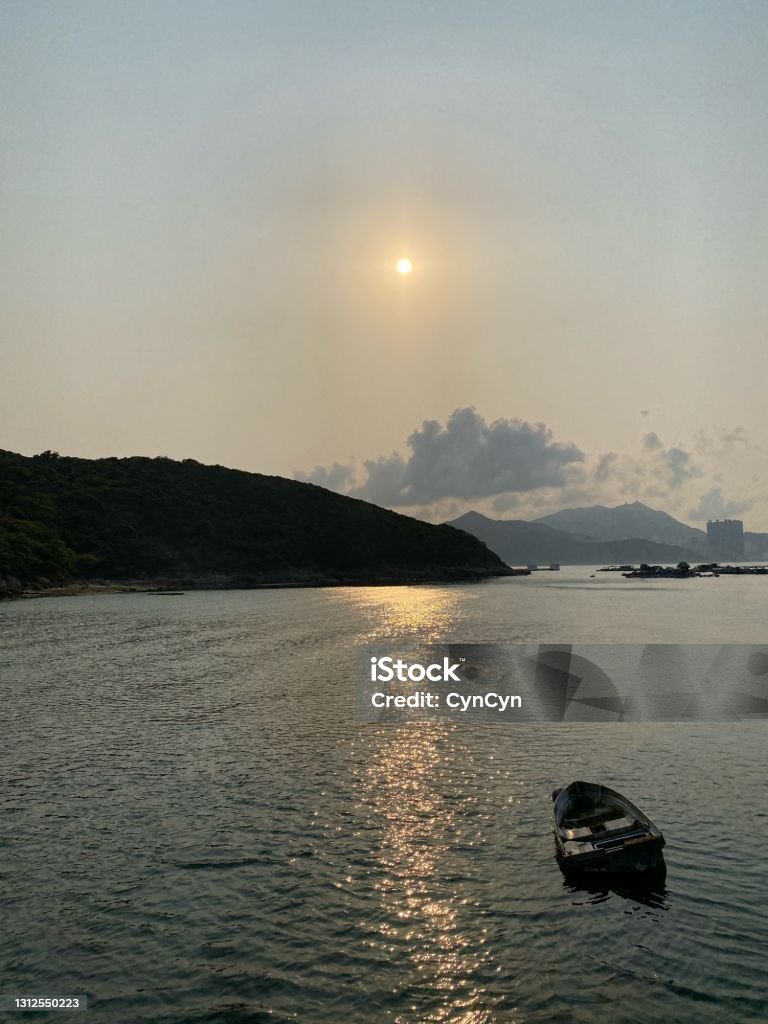 The sun is always there A little rowing boat under the guiding light of the sun at Tung Lung Island, Hong Kong Color Image Stock Photo