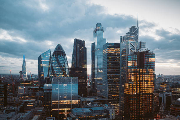 The City of London Skyline at Night, United Kingdom Aerial panoramic view of The City of London cityscape skyline with metropole financial district modern skyscrapers after sunset on night with illuminated buildings and cloudy sky in London, UK city of london stock pictures, royalty-free photos & images