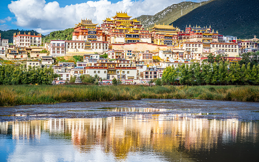 Songzanlin monastery with beautiful water reflection on lake in Shangri-La Yunnan China