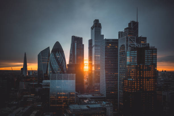 Sunset over The City of London, United Kingdom Aerial panoramic view of The City of London cityscape skyline with metropole financial district modern skyscrapers during sunrise with illuminated buildings and cloudy sky in London, UK city of london stock pictures, royalty-free photos & images
