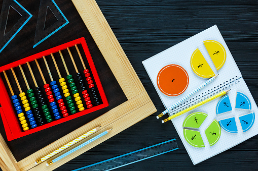 colorful math fractions on wooden background or table. interesting math for kids. Education, back to school concept. Geometry and mathematics materials.