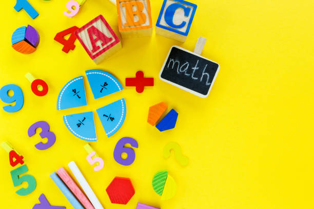 istock Colorful math fractions on yellow background. Blocks with title School on the table. Interesting, fun math for kids. Education, back to school concept 1312563863