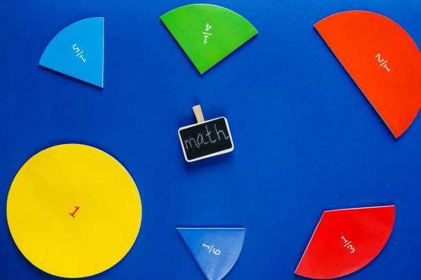 istock Colorful math fractions and black chalkboard on classic blue background. Interesting, fun math for kids. Education, back to school concept 1312563975