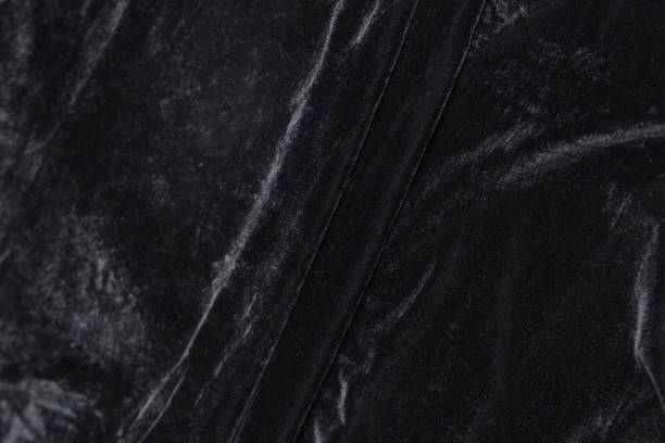 istock Colored black textile satin fabric folded in folds and waves with highlights and texture 1312567096