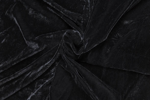 istock Colored black textile satin fabric folded in folds and waves with highlights and texture 1312567154
