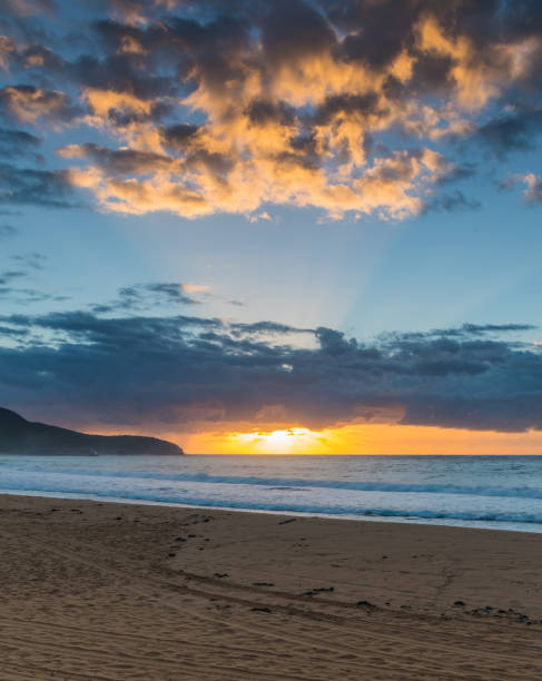 istock Sunrise seascape with clouds and sun rays 1312568677