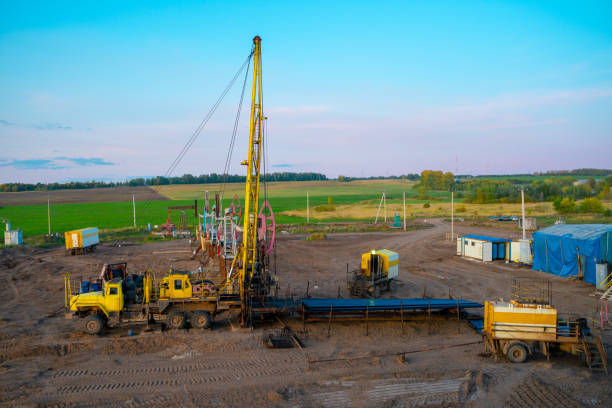 istock Workover rig working on a previously drilled well trying to restore production through repair. The pumping units and well workover operation. 1312570405