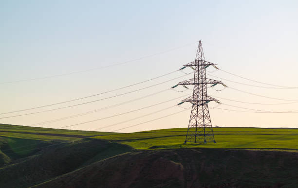 Power line support in green field stock photo