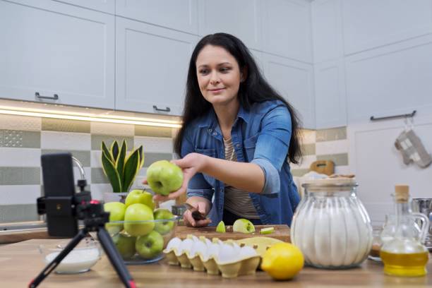 istock Woman cooking at home in kitchen, talking online using video call on smartphone 1312575340