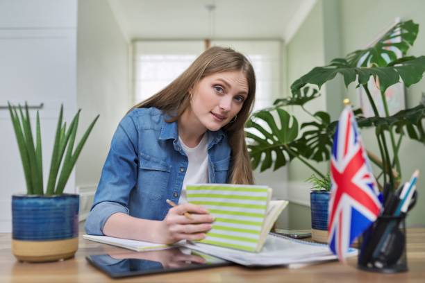 istock UK learning English online. Female student remotely looking at webcam 1312575402
