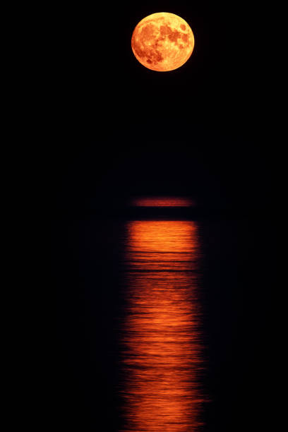 istock Super full blood moon and moon light over the sea 1312576267