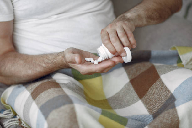 istock Senior man with pills sitting in bed 1312576860