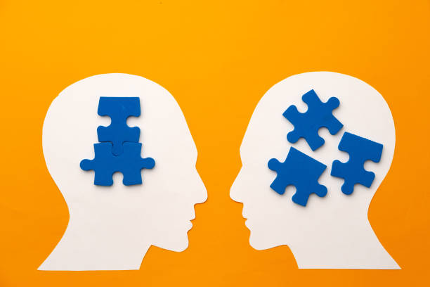 istock Papercut head silhouette with puzzle pieces on yellow background 1312581573