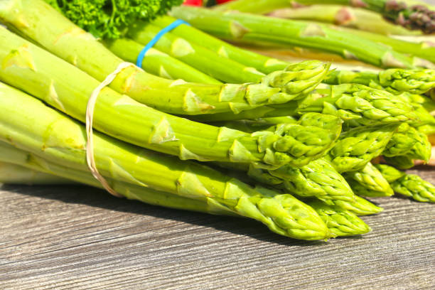 istock Green asparagus decorated on a rustic wooden table 1312582692