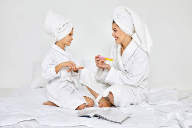 istock mother and daughter holding nail file and making manicure 1312583045