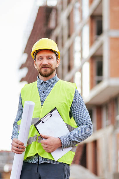 istock Portrait of an engineer holding a blueprint at a construction site 1312585982