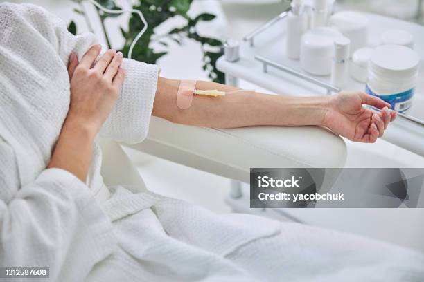 Young Female In White Bathrobe During Medical Procedure In Beauty Clinic Stock Photo - Download Image Now