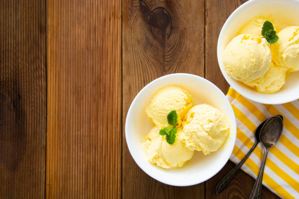 istock Vanilla ice cream scoops sundae in bowl on wooden background, copy space 1312592632