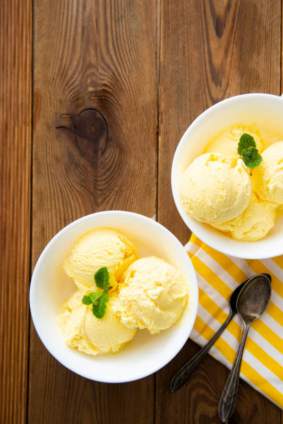 istock Vanilla ice cream scoops sundae in bowl on wooden background, copy space 1312592897