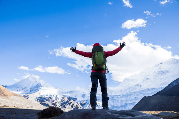 istock Successful woman backpacker hiking in winter mountains 1312593570