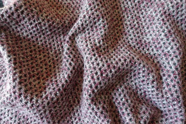 istock Pink, grey and white woolen fabric with diamonds pattern in soft folds 1312594208