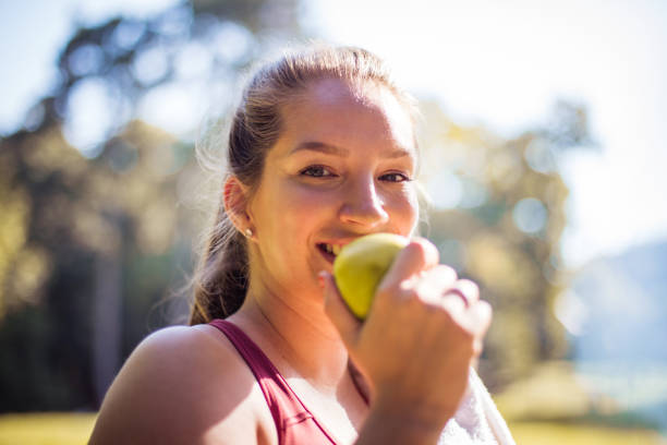 istock Woman in the park eating apple. 1312596746