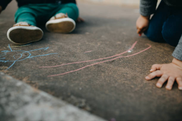 istock Child Drawing With Colored Chalk On The Floor 1312597887