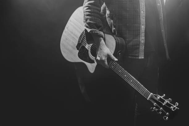 istock A man holding an acoustic guitar in his hands. 1312597944