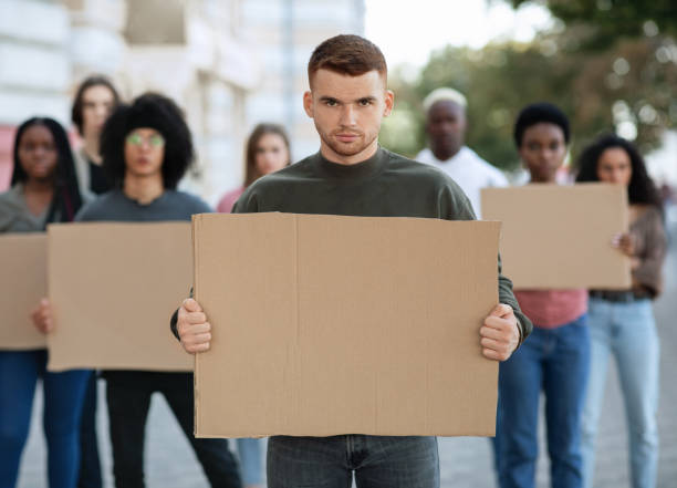 istock Confident guy leading a group of demonstrators with placards 1312598127