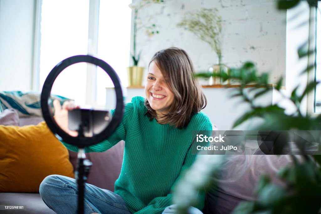 Young influencer woman streaming live video with smartphone and led Influencer Stock Photo