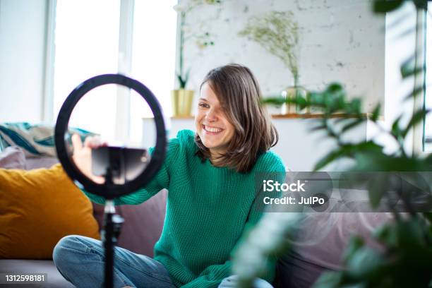 Young Influencer Woman Streaming Live Video With Smartphone And Led Stock Photo - Download Image Now