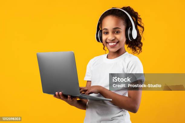 Black Girl In Headphones Standing With Laptop At Studio Stock Photo - Download Image Now