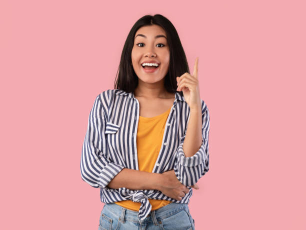 istock Excited asian woman has great idea and points finger up 1312598438