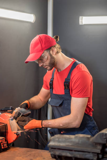 istock Attentive man machining detail on grinding machine 1312599550