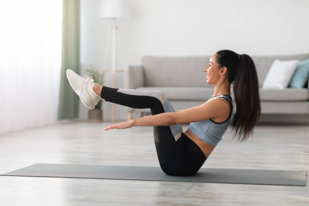 istock Sporty young woman training at home, working on abs 1312600267