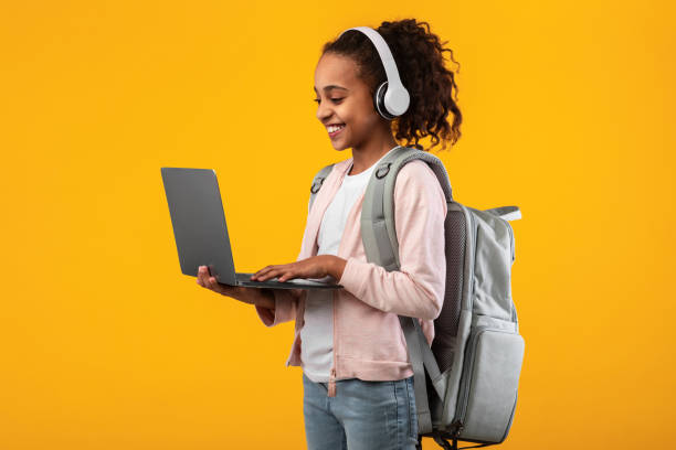 istock Black girl wearing headset standing with laptop at studio 1312600424